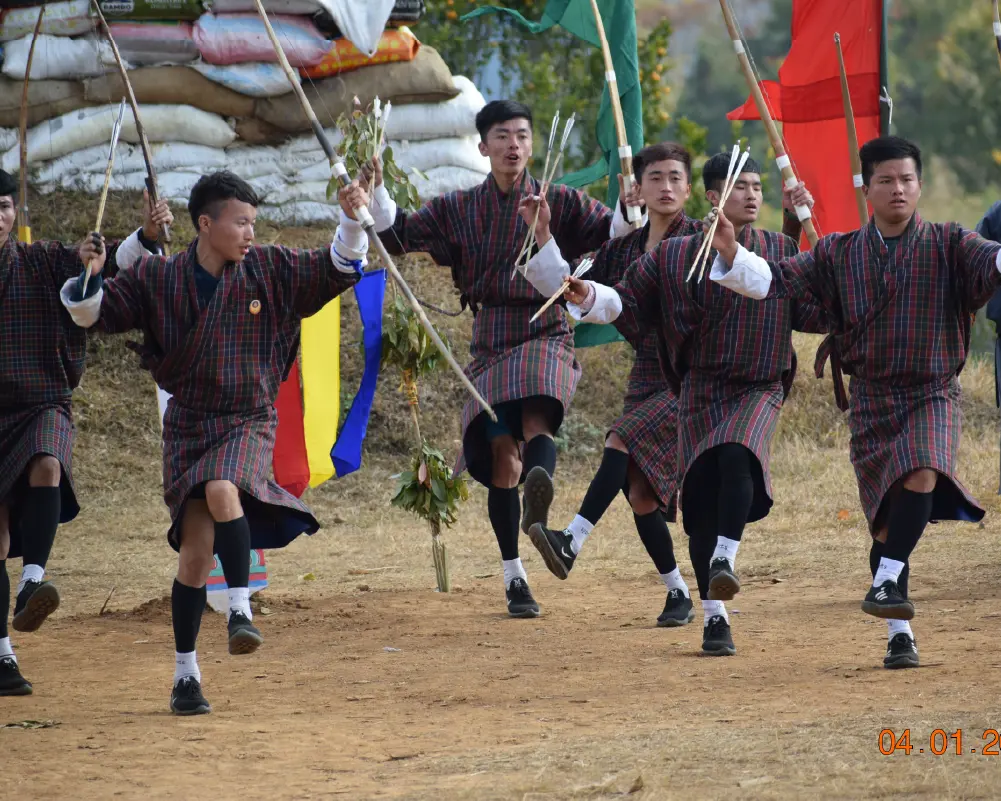young mens on bhutanese gho playing archery